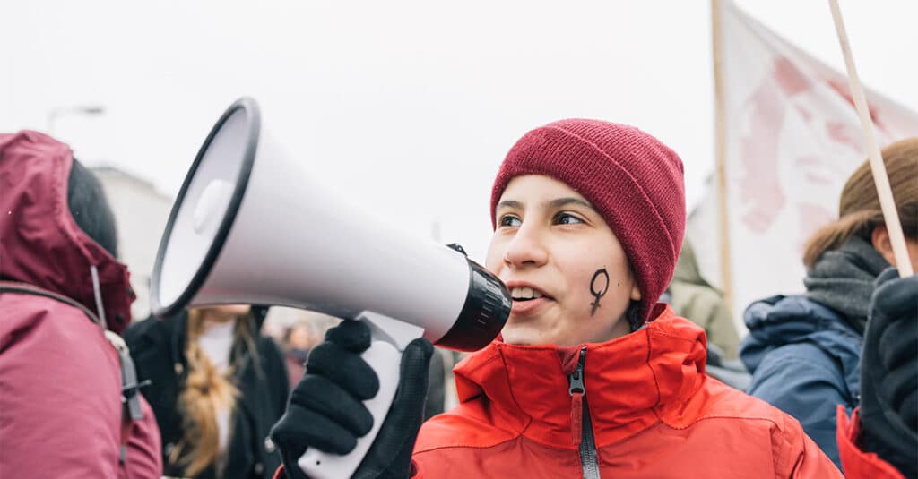 vrouw bij een mars met megafoon